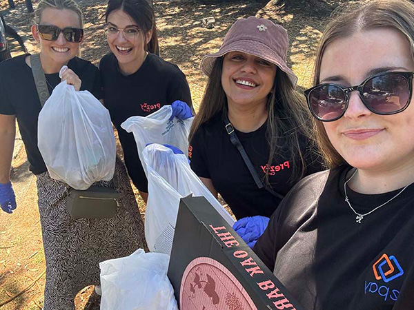 epay New Zealand team members collecting litter along Mission Bay beach during their Day of Caring community clean-up event