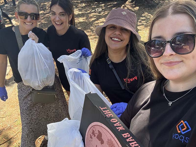 epay New Zealand team members collecting litter along Mission Bay beach during their Day of Caring community clean-up event