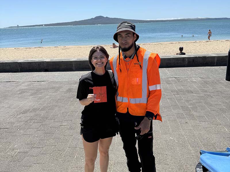 epay New Zealand team members collecting litter along Mission Bay beach during their Day of Caring community clean-up event