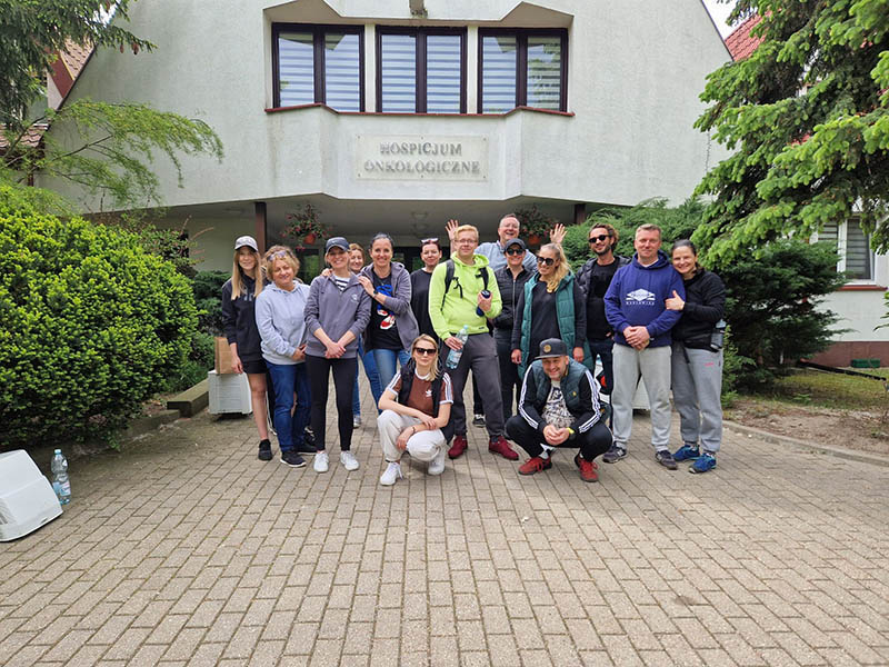 Euronet Polska employees planting flowers and tidying up the area around Fundacja Hospicjum Onkologiczne św. Krzysztofa in Warsaw.