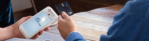 A photo showing a transaction between a card and POS terminal
