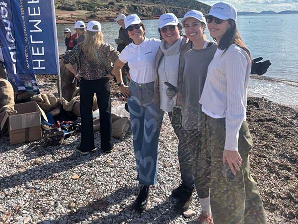 Volunteers participating in a beach clean-up at Varkiza Beach to protect marine life and reduce pollution.